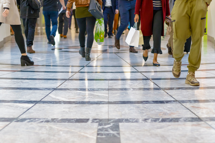 A modern floor with legs of a crowd walking in a shopping mall