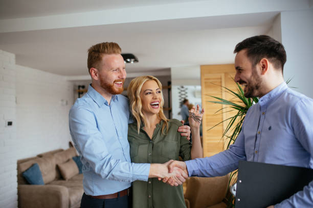 Portrait of financial adviser congratulating to a young couple for buying a new house.