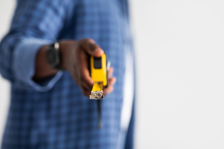 African american handyman holding measuring tape how much space average square footage - square feet