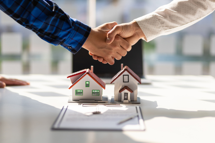 Los agentes inmobiliarios se dan la mano después de que se completa la firma del contrato.